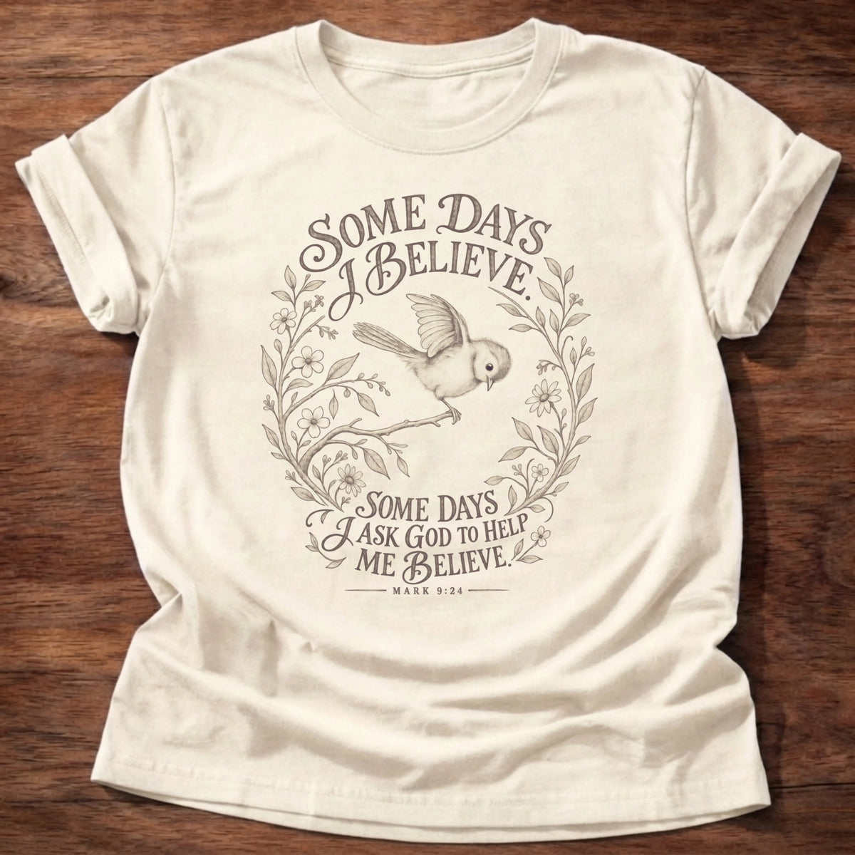 Natural colored t-shirt with 'Some days I believe. Some days I ask God to hold my belief.' bird and wreath design, Mark 9:24 shirt