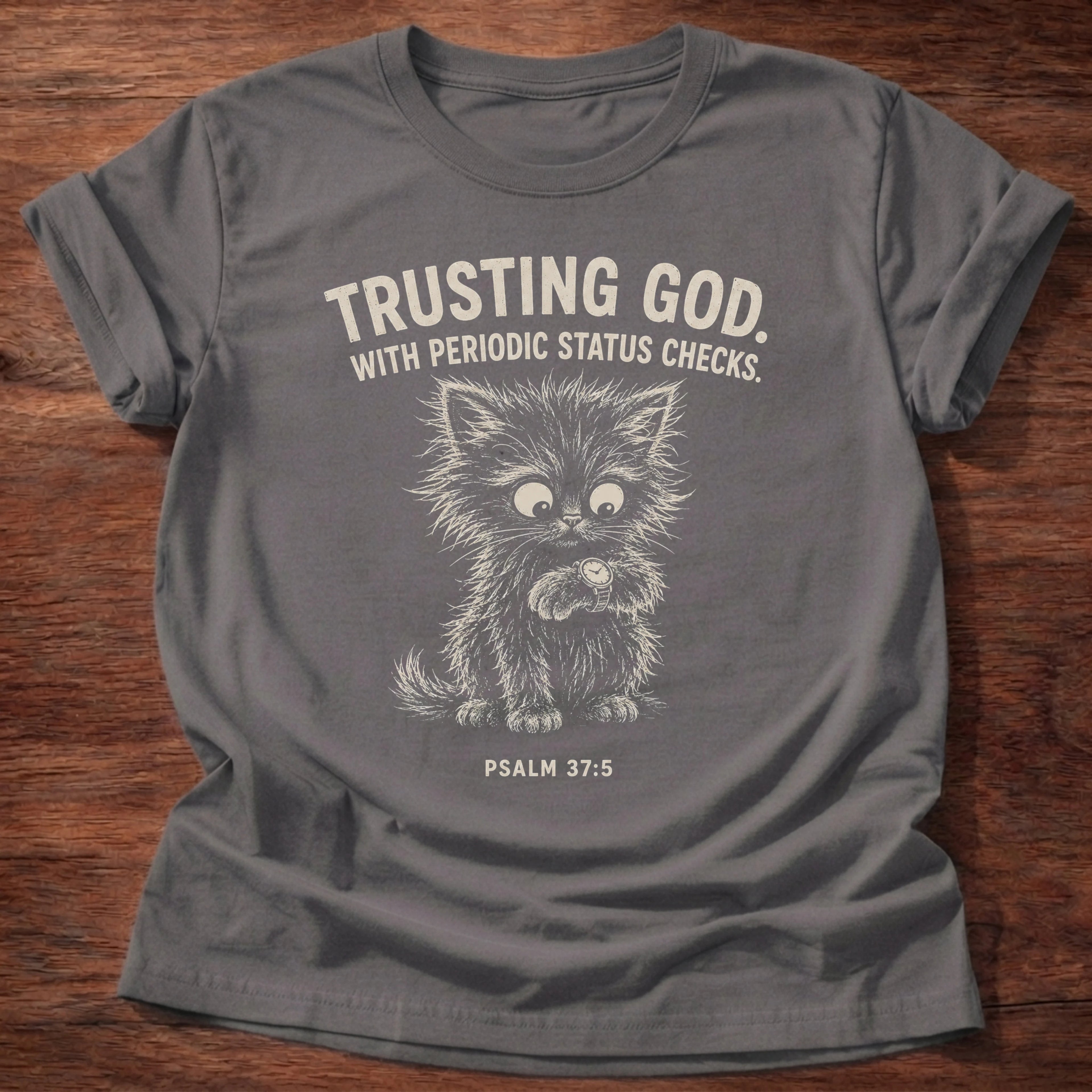 Charcoal t-shirt with a cat illustration and 'Trusting God with periodic status checks' Psalm 37:5, a funny anxious Christian shirt