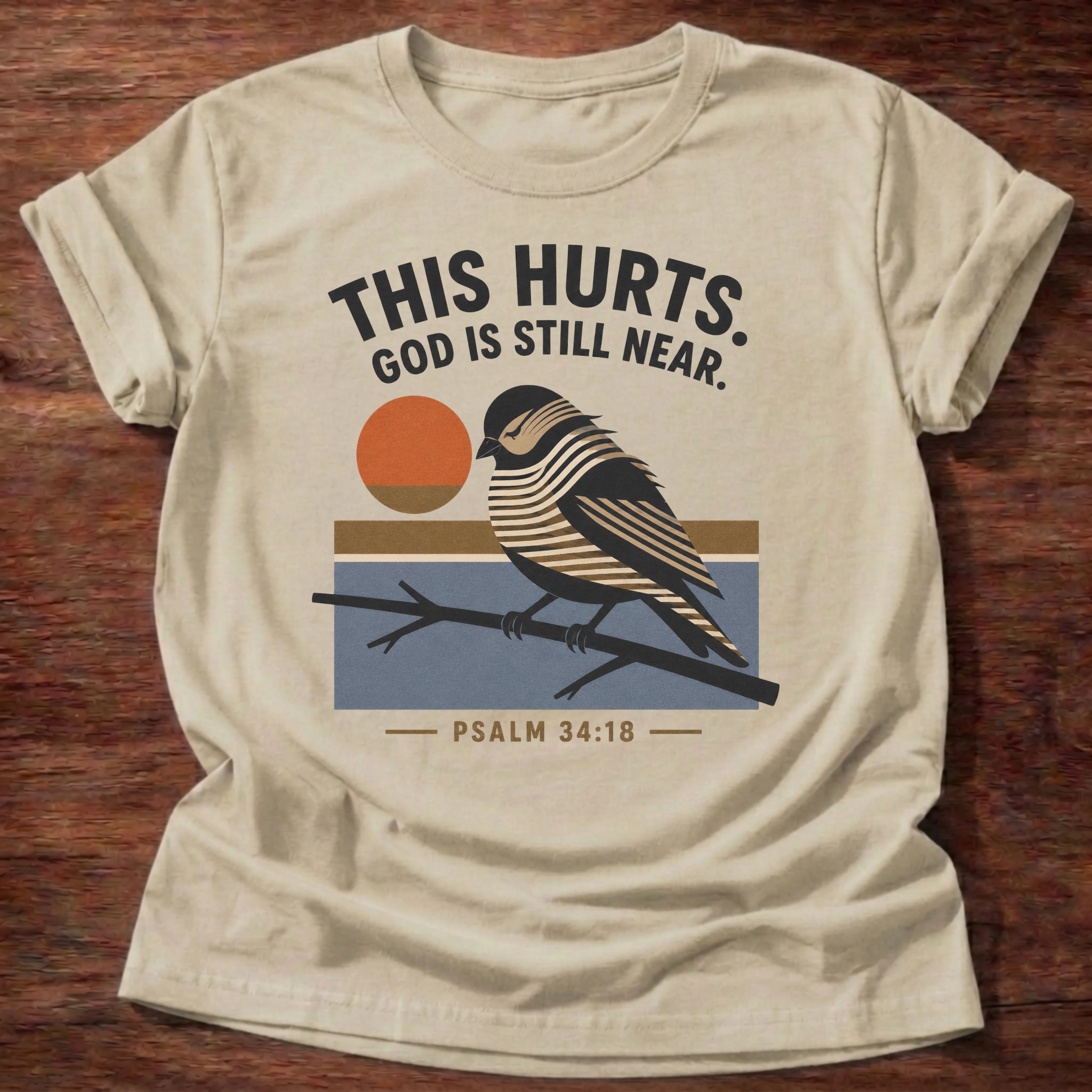 Still Near T-Shirt in Sand featuring bird illustration and Psalm 34:18 comfort design
