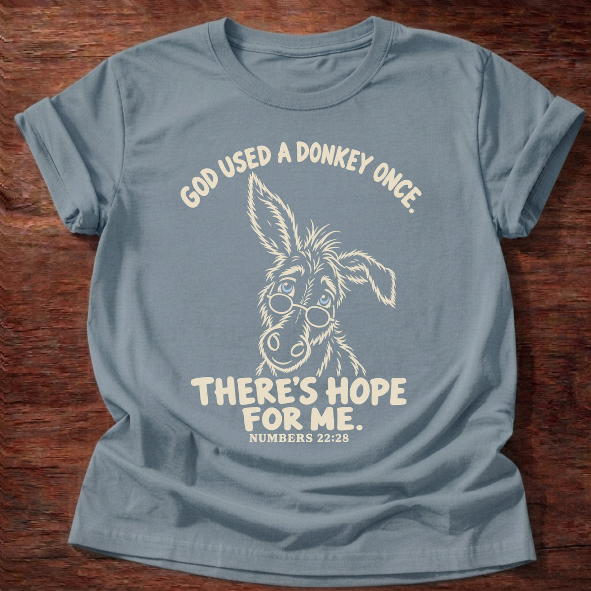 Stone Blue t-shirt printed with a hand-drawn donkey and “God used a donkey once. There's hope for me.” Numbers 22:28 Christian shirt
