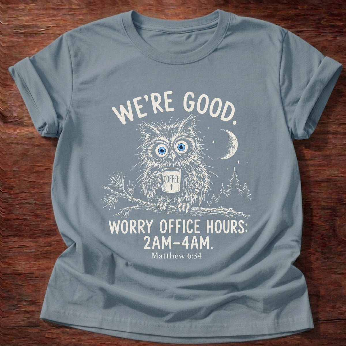 Stone Blue t-shirt printed with a wide-eyed owl holding a mug on a moonlit branch graphic and “We're good. Worry office hours: 2AM-4AM.” Matthew 6:34 Christian shirt