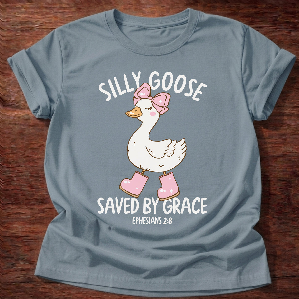 Stone Blue t-shirt printed with a goose wearing a pink bow and pink boots and “Silly Goose. Saved by Grace.” Ephesians 2:8 Christian shirt