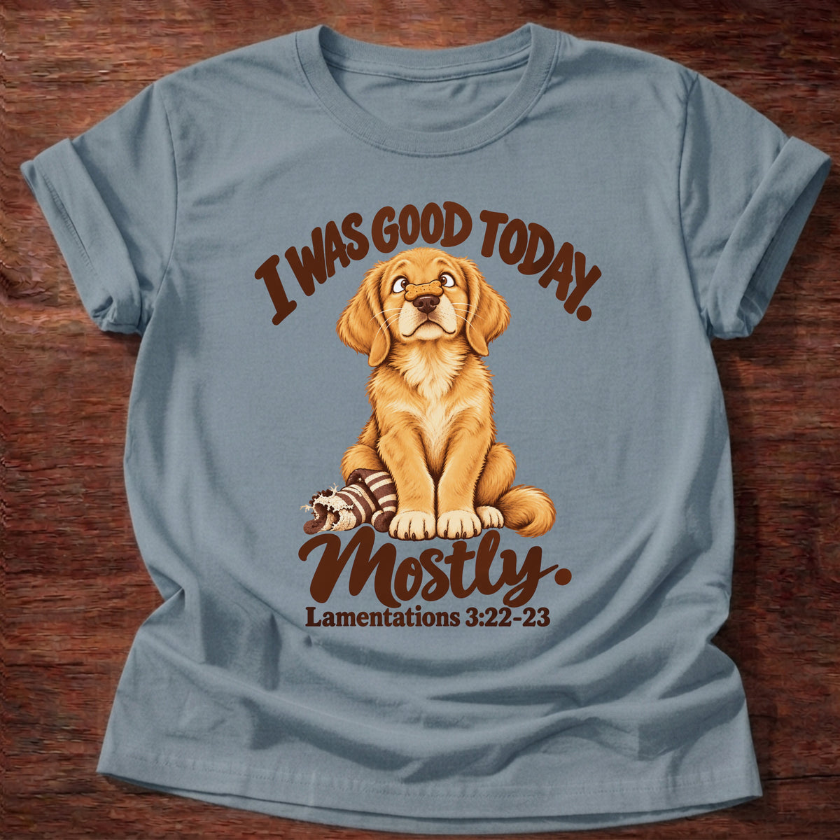 Stone Blue t-shirt printed with a golden retriever puppy sitting beside a chewed-up toy and “I was good today. Mostly.” Lamentations 3:22-23 Christian shirt