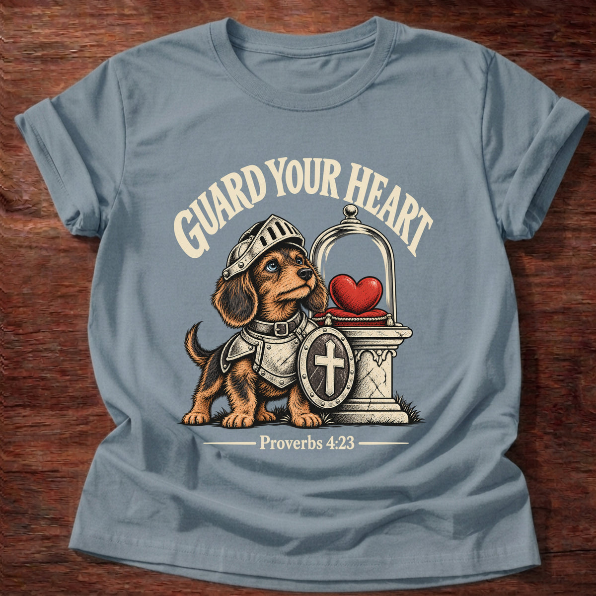 Stone Blue t-shirt printed with a brave knight dachshund in armor guarding a glowing heart graphic and “Guard your heart.” Proverbs 4:23 Christian shirt