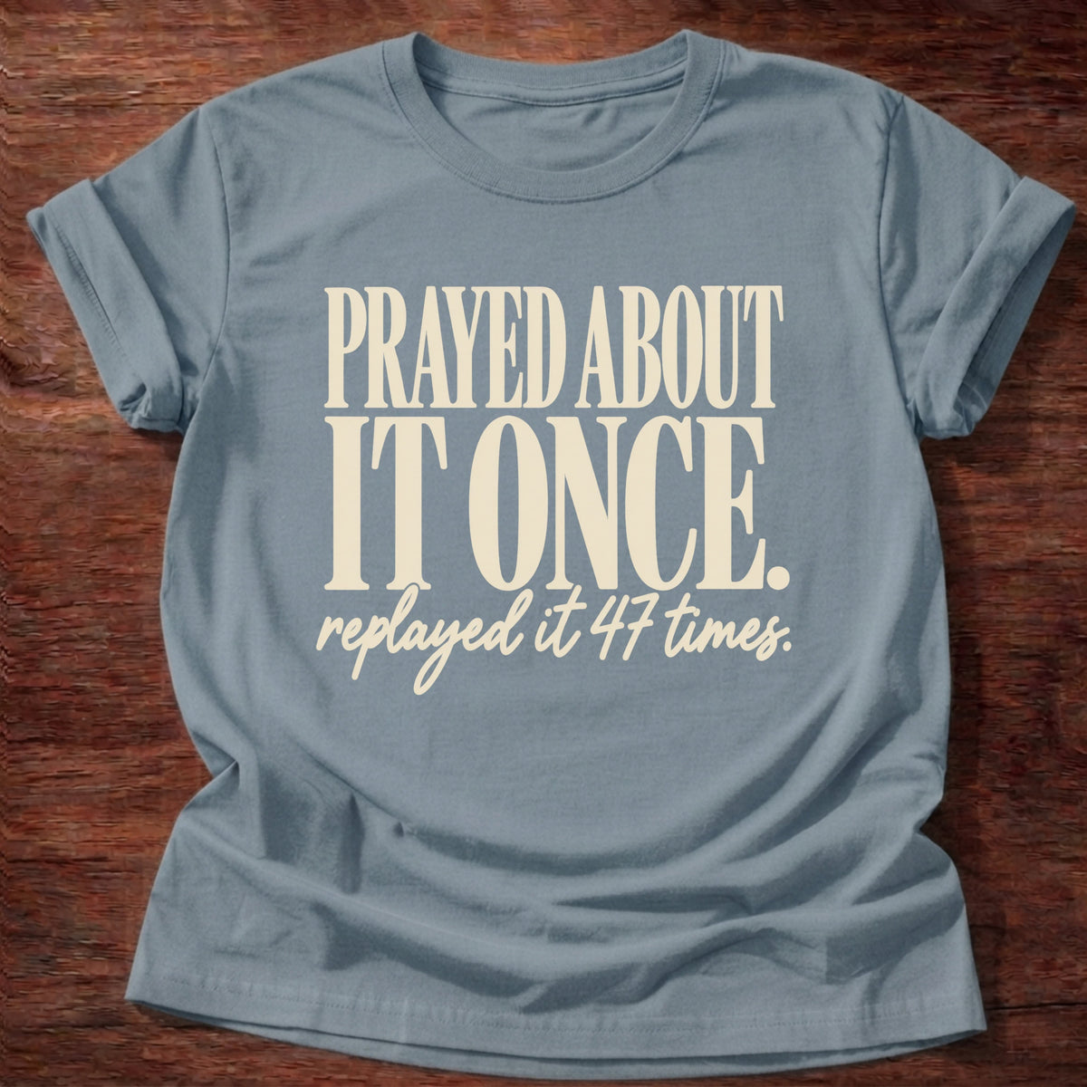 Replayed It Forty-Seven T-Shirt in Stone Blue featuring Prayed About It Once replayed it 47 times funny Christian overthinker typography design with script punchline