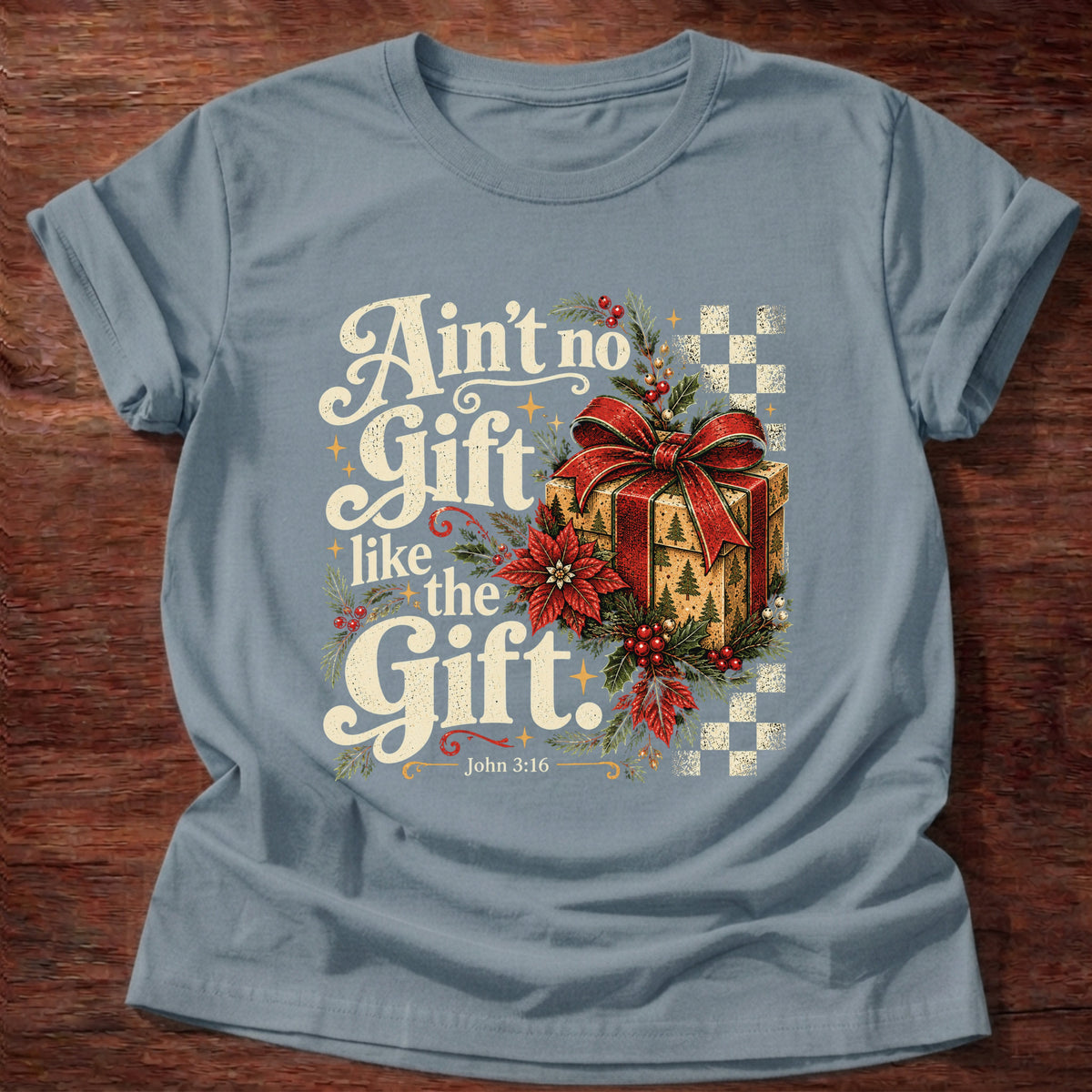 Stone Blue t-shirt printed with a retro wrapped Christmas present with poinsettias and checkerboard graphic and “Ain't no Gift like the Gift.” John 3:16 Christian shirt