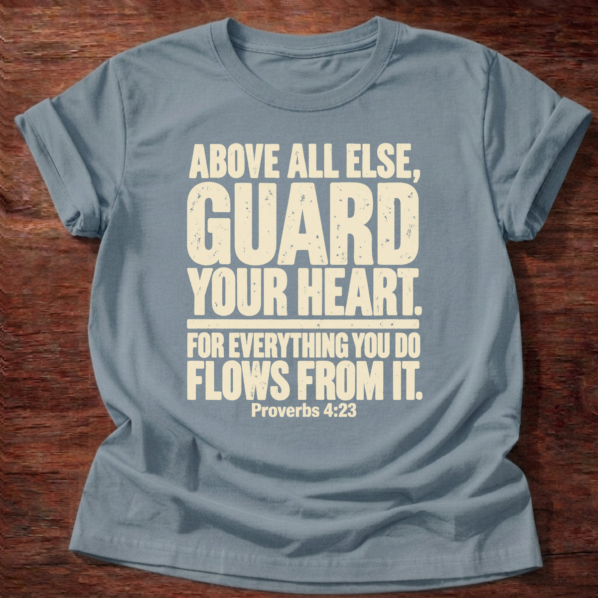 Stone Blue t-shirt printed with bold stacked typography graphic and “Above all else, guard your heart, for everything you do flows from it.” Proverbs 4:23 Christian shirt