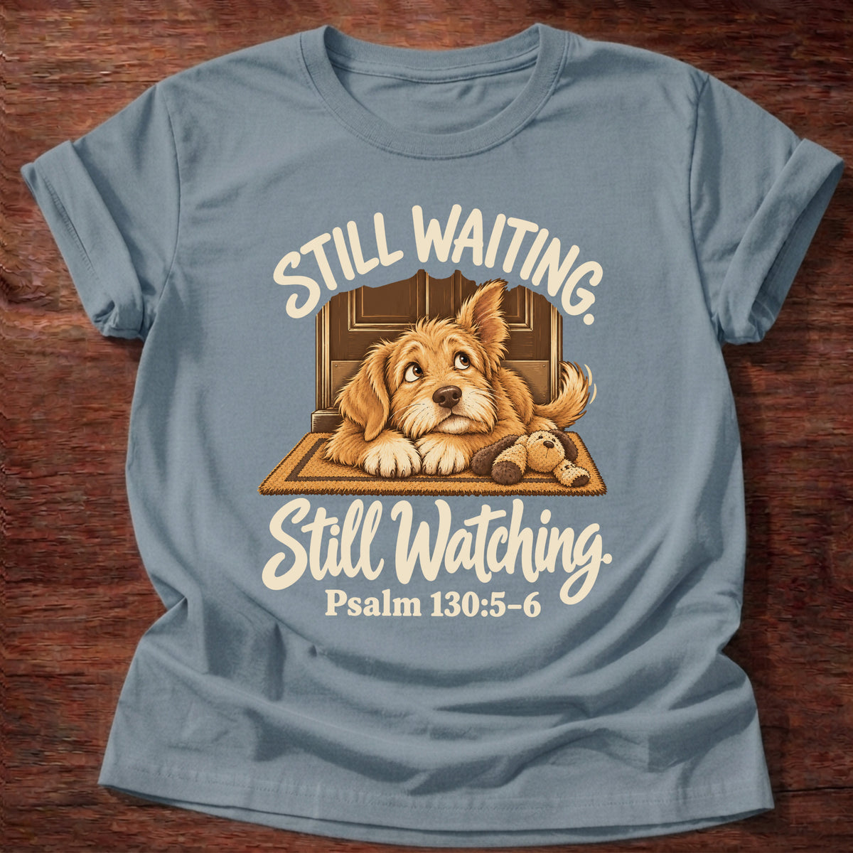 Stone Blue t-shirt printed with a puppy lying on a doormat waiting at the door and “Still waiting. Still watching.” Psalm 130:5-6 Christian shirt