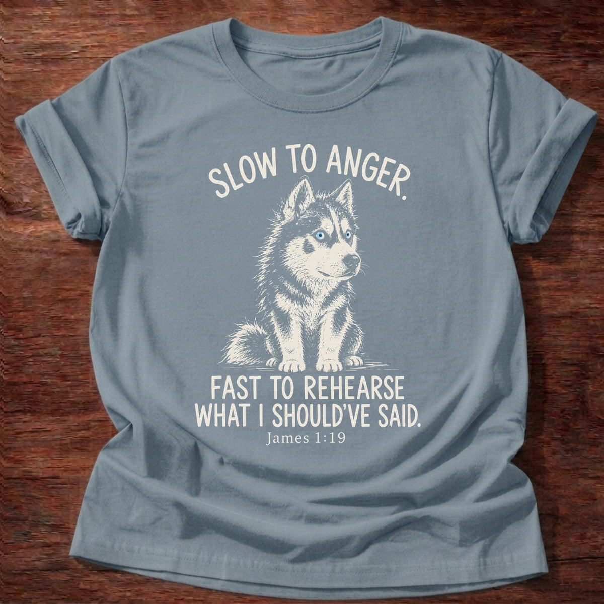 Slow To Anger T-Shirt in Stone Blue featuring a blue-eyed husky puppy sitting calmly and James 1:19 patience humor design