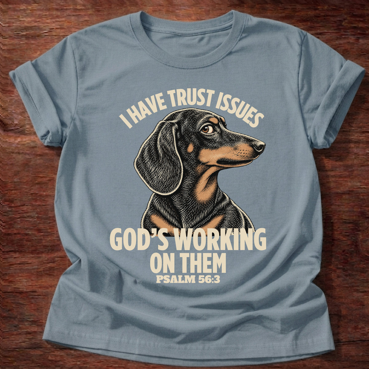 Stone Blue t-shirt printed with a wary dachshund puppy and “I have trust issues. God's working on them.” Psalm 56:3 Christian shirt