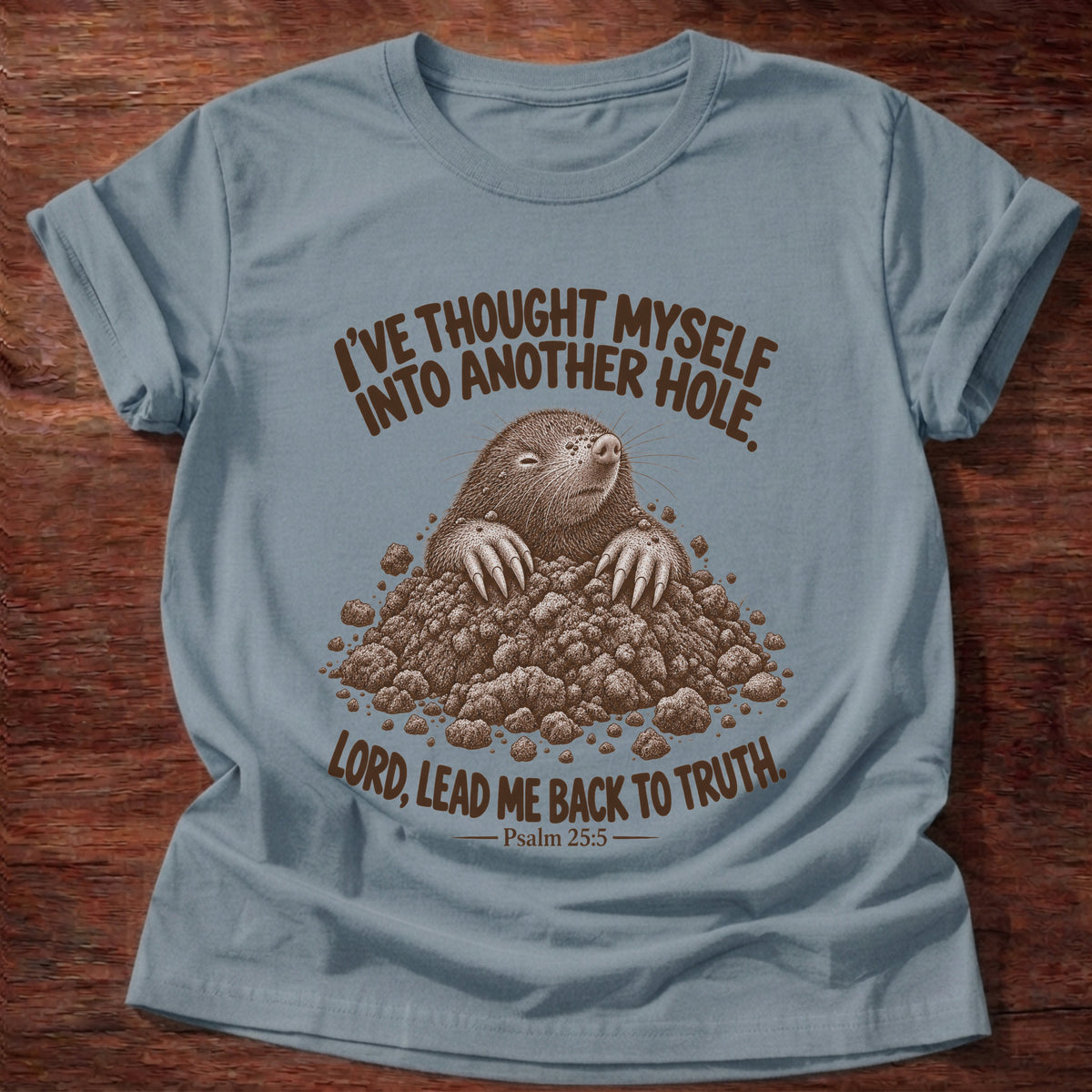 Stone Blue t-shirt printed with a mole poking out of a mound of dirt graphic and “I've thought myself into another hole. Lord, lead me back to truth.” Psalm 25:5 faith based gift