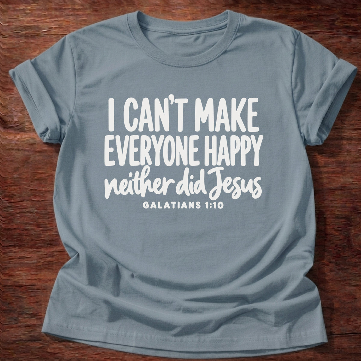 Stone Blue t-shirt printed with bold hand-lettered typography graphic and “I can't make everyone happy. Neither did Jesus.” Galatians 1:10 Christian shirt