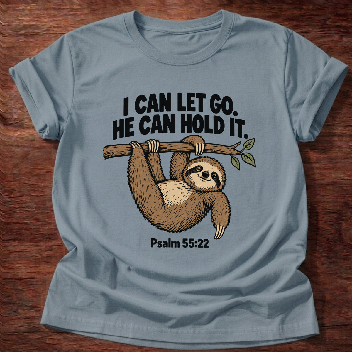 Stone Blue t-shirt printed with a sloth hanging from a branch graphic and 'I can let go. He can hold it.' Psalm 55:22 faith based gift