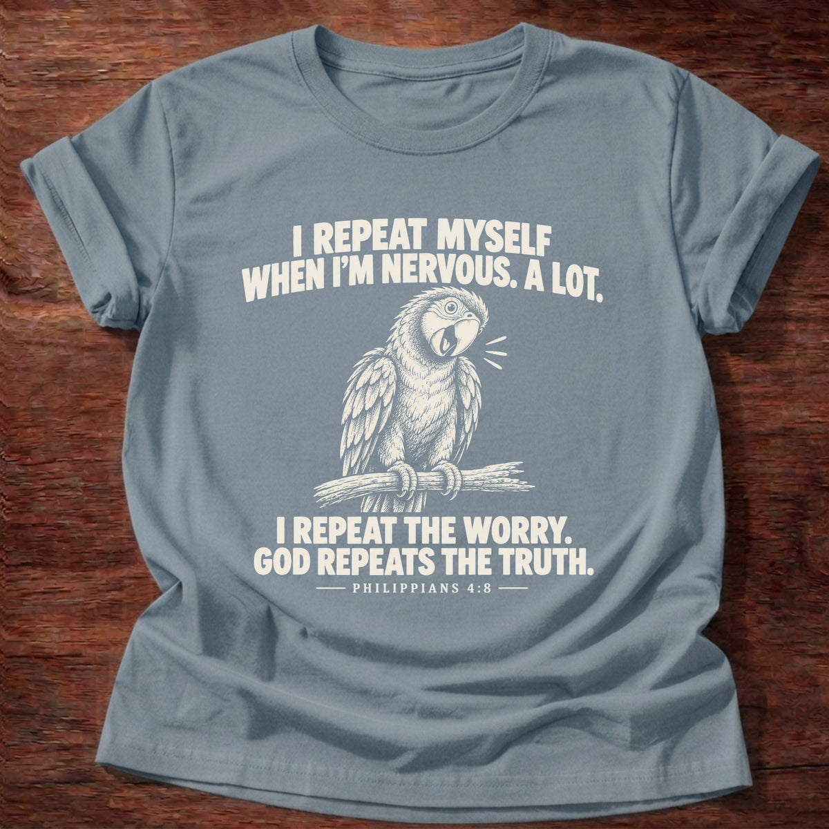 Stone Blue t-shirt printed with a parrot squawking on a perch graphic and 'I repeat myself when I'm nervous. A lot. I repeat the worry. God repeats the truth.' Philippians 4:6 faith based gift