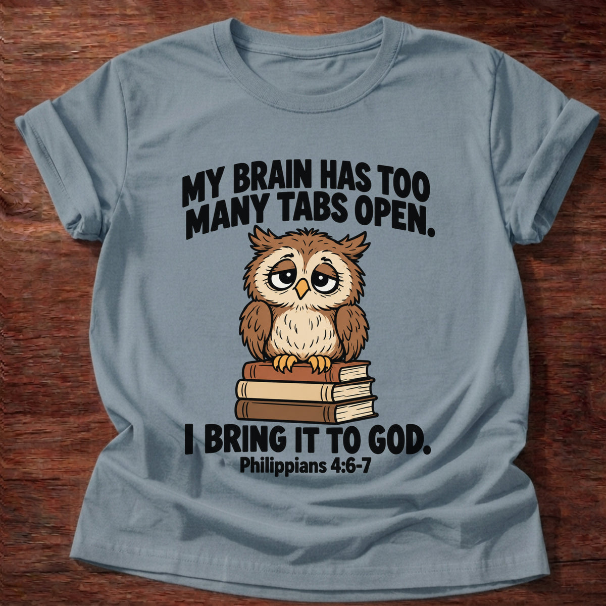 Stone Blue t-shirt printed with an owl surrounded by books graphic and 'My brain has too many tabs open. I bring it to God.' Philippians 4:6-7 faith based gift