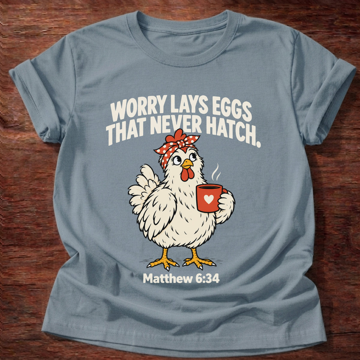 Stone Blue t-shirt printed with a chicken holding a tea cup graphic and 'Worry lays eggs that never hatch. I bring it to God.' Matthew 6:34 faith based gift