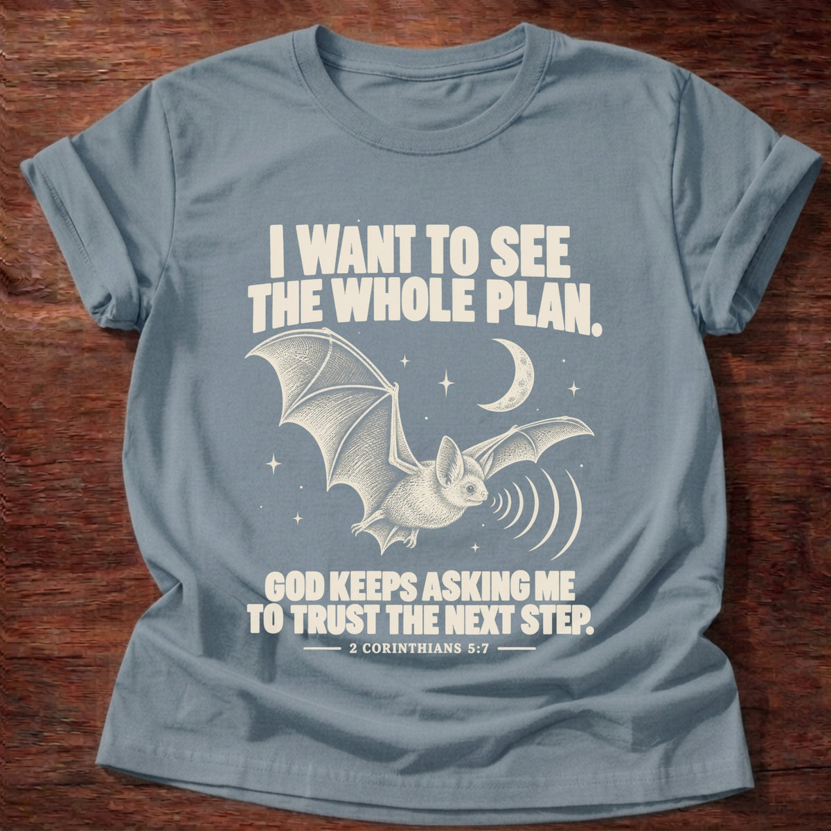 Stone Blue t-shirt printed with a bat flying under a night sky graphic and 'I want to see the whole plan. God keeps asking me to trust the next step.' 2 Corinthians 5:7 faith based gift