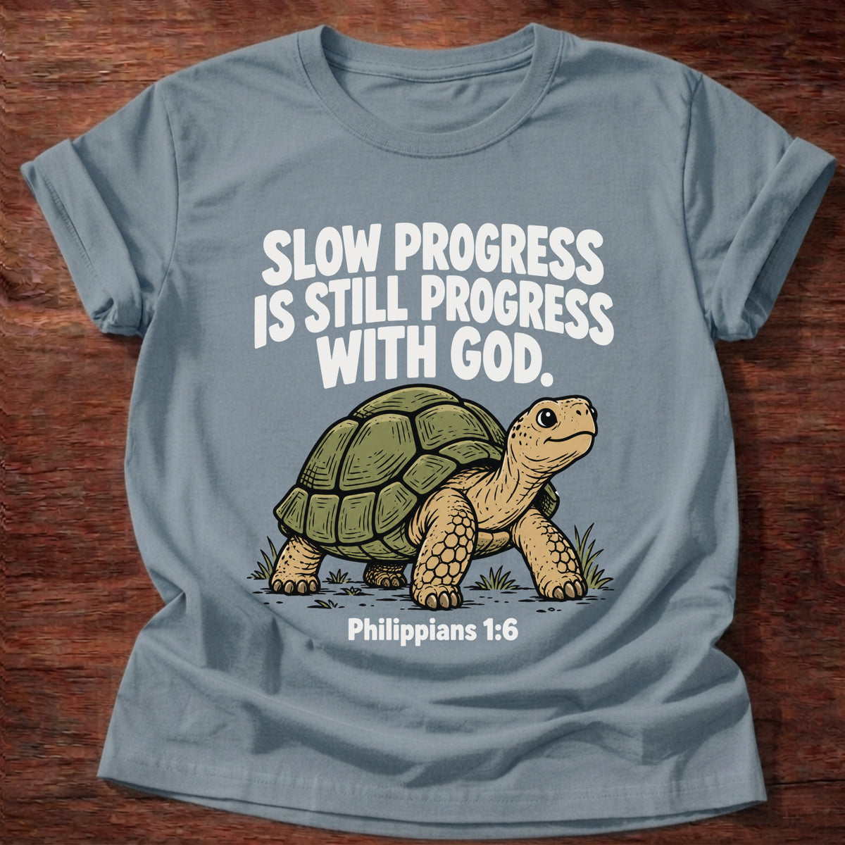Stone Blue t-shirt printed with a turtle graphic and 'Slow progress is still progress with God.' Philippians 1:6 faith based gift