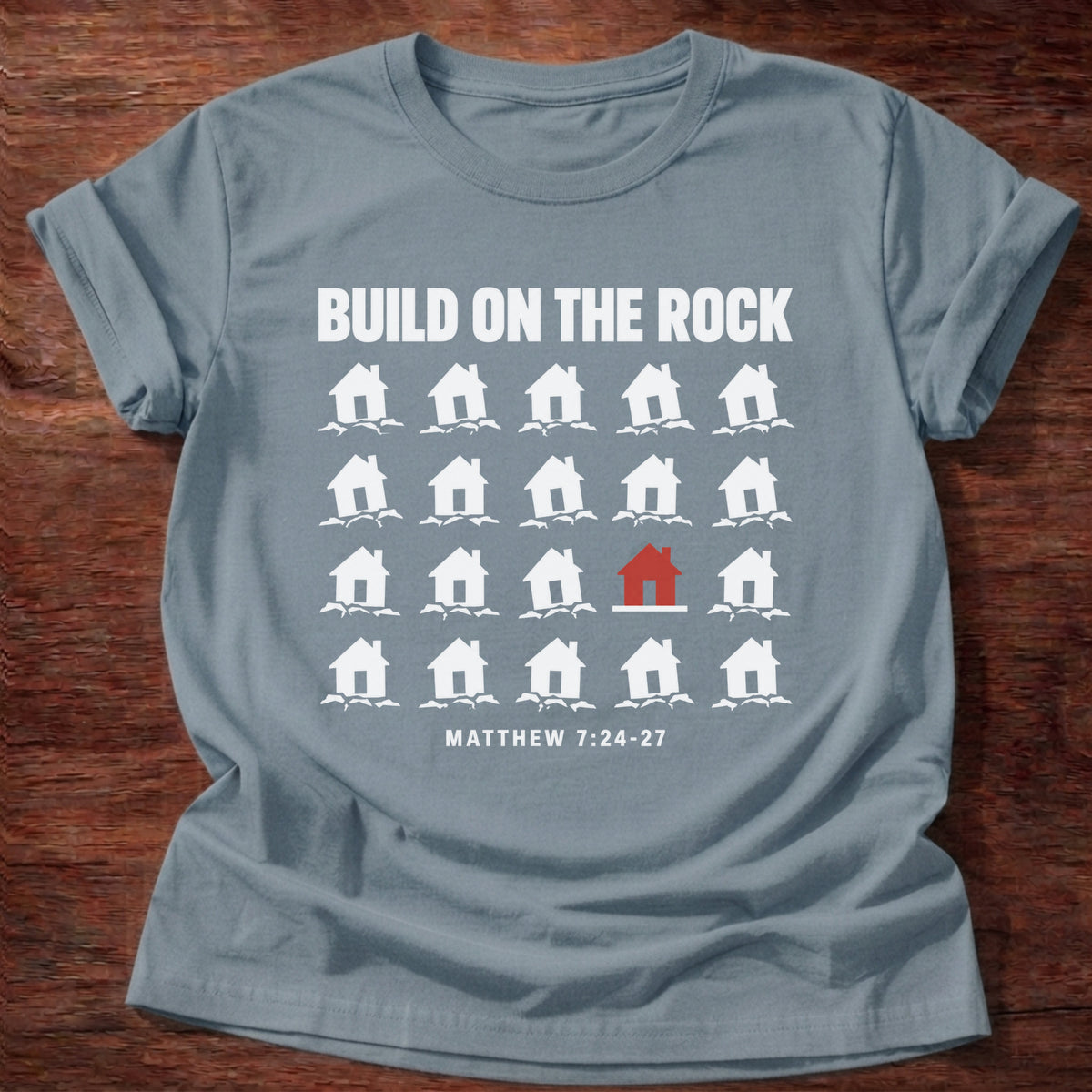 Stone Blue t-shirt printed with a row of houses graphic and 'Build on the rock.' Matthew 7:24-27 faith based gift