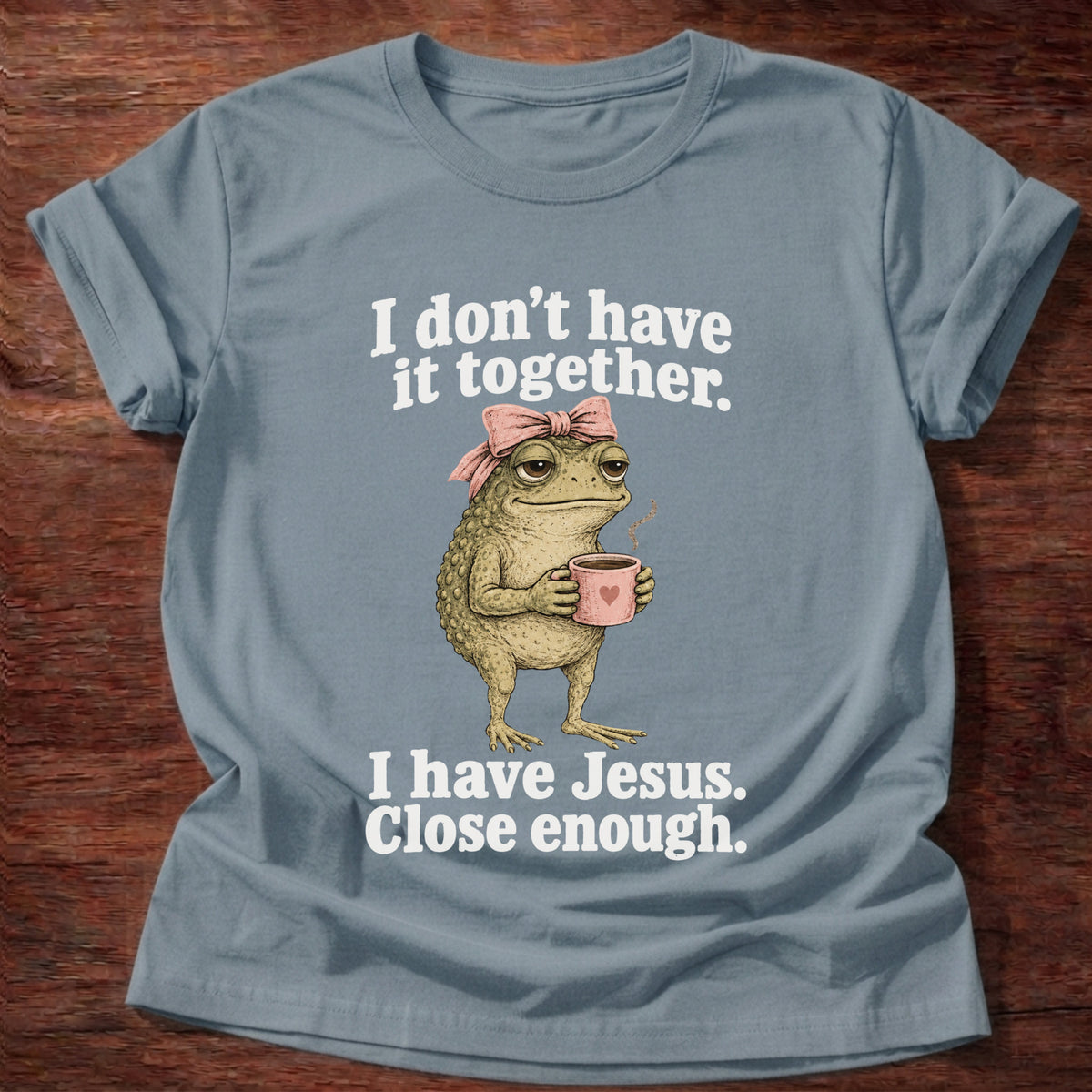 Stone Blue t-shirt printed with a frog holding a tea cup graphic and 'I don't have it together. I have Jesus. Close enough.' 2 Corinthians 12:9 faith based gift