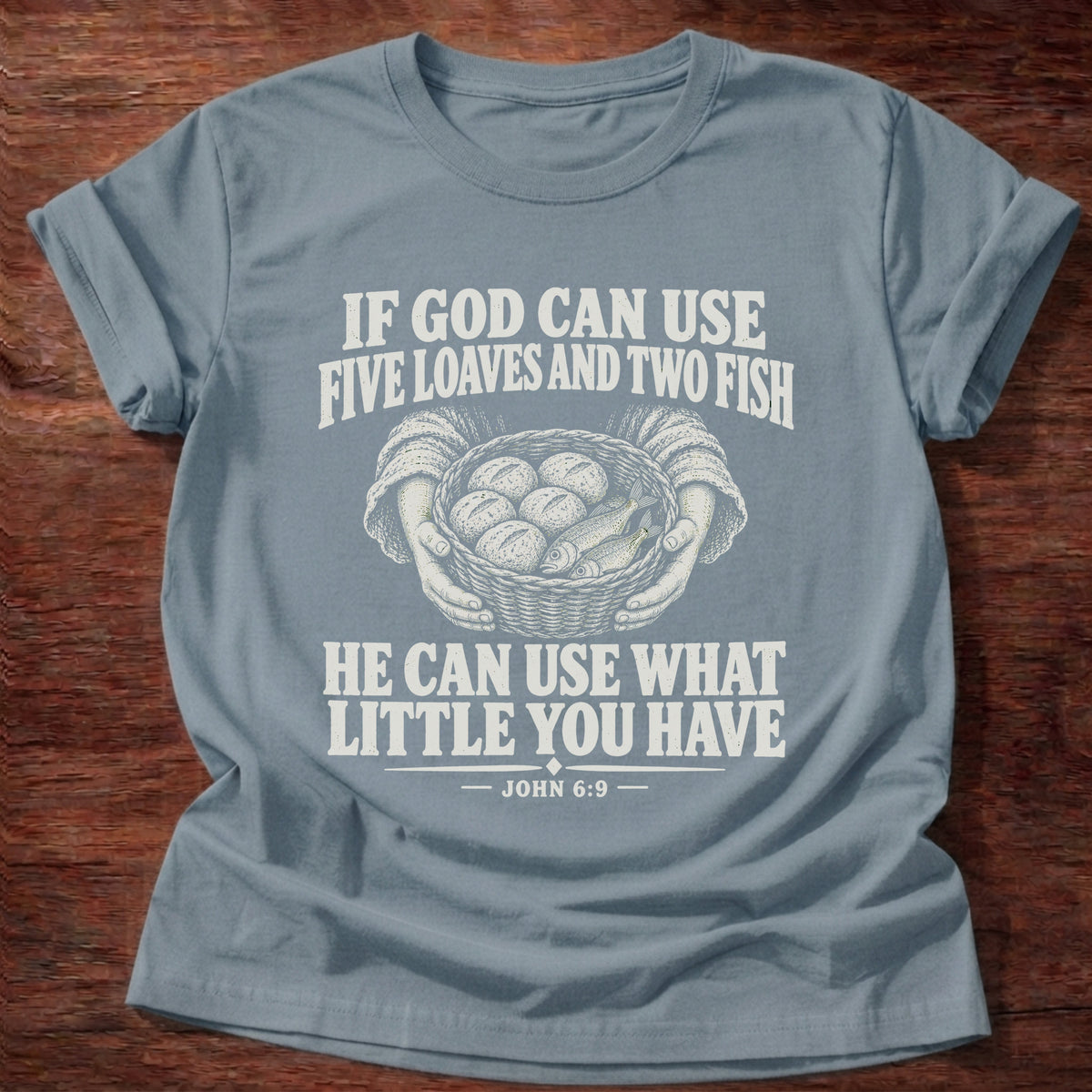 Stone Blue t-shirt printed with a basket of loaves and fish graphic and 'If God can use five loaves and two fish, He can use what little you have.' John 6:9 faith based gift