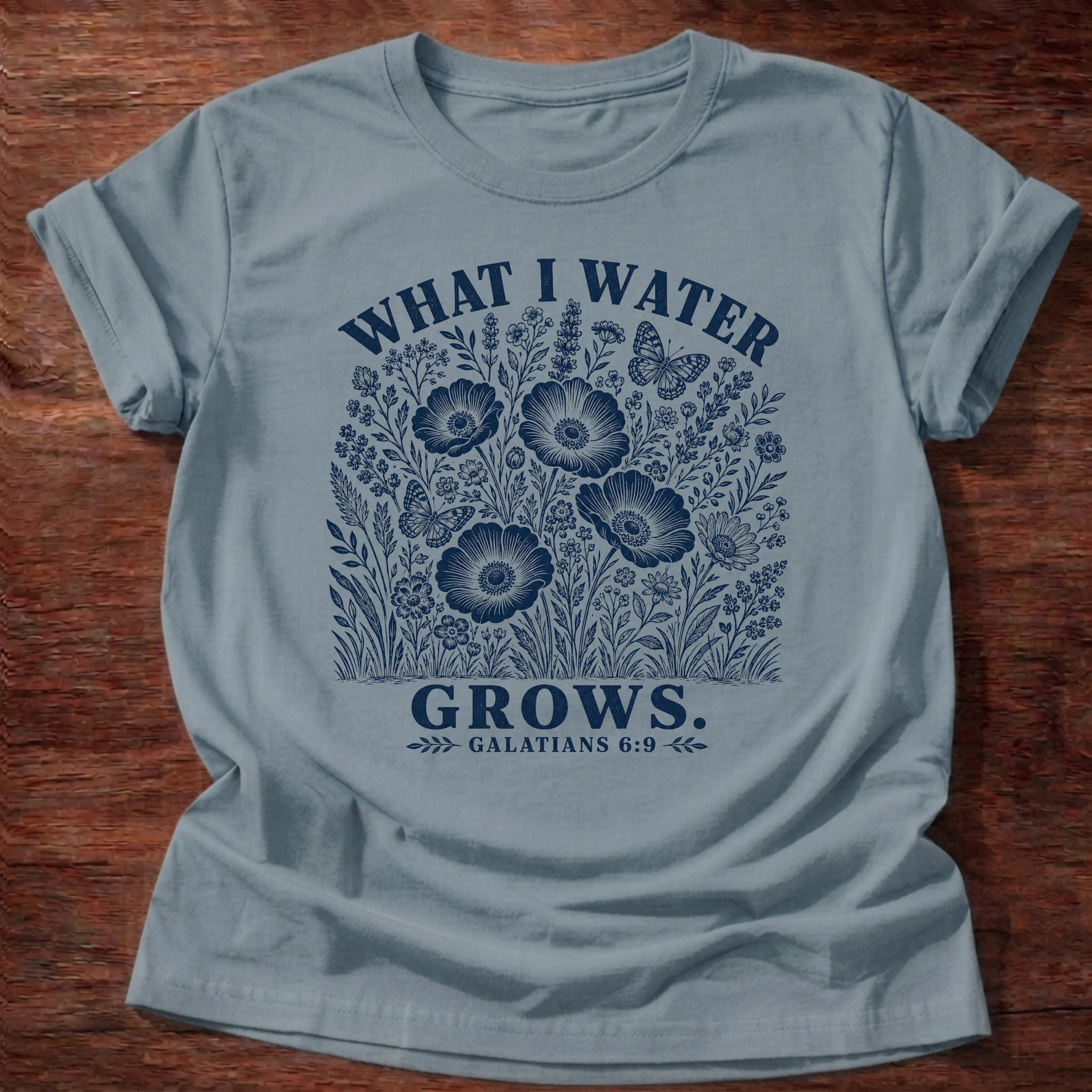 Stone Blue Gildan 64000 t-shirt with a blue flower illustration and 'What I Water Grows' text, Galatians 6:9 Christian t-shirt